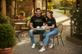 Hispanic male and female models wearing black Gucci stripe logo tee